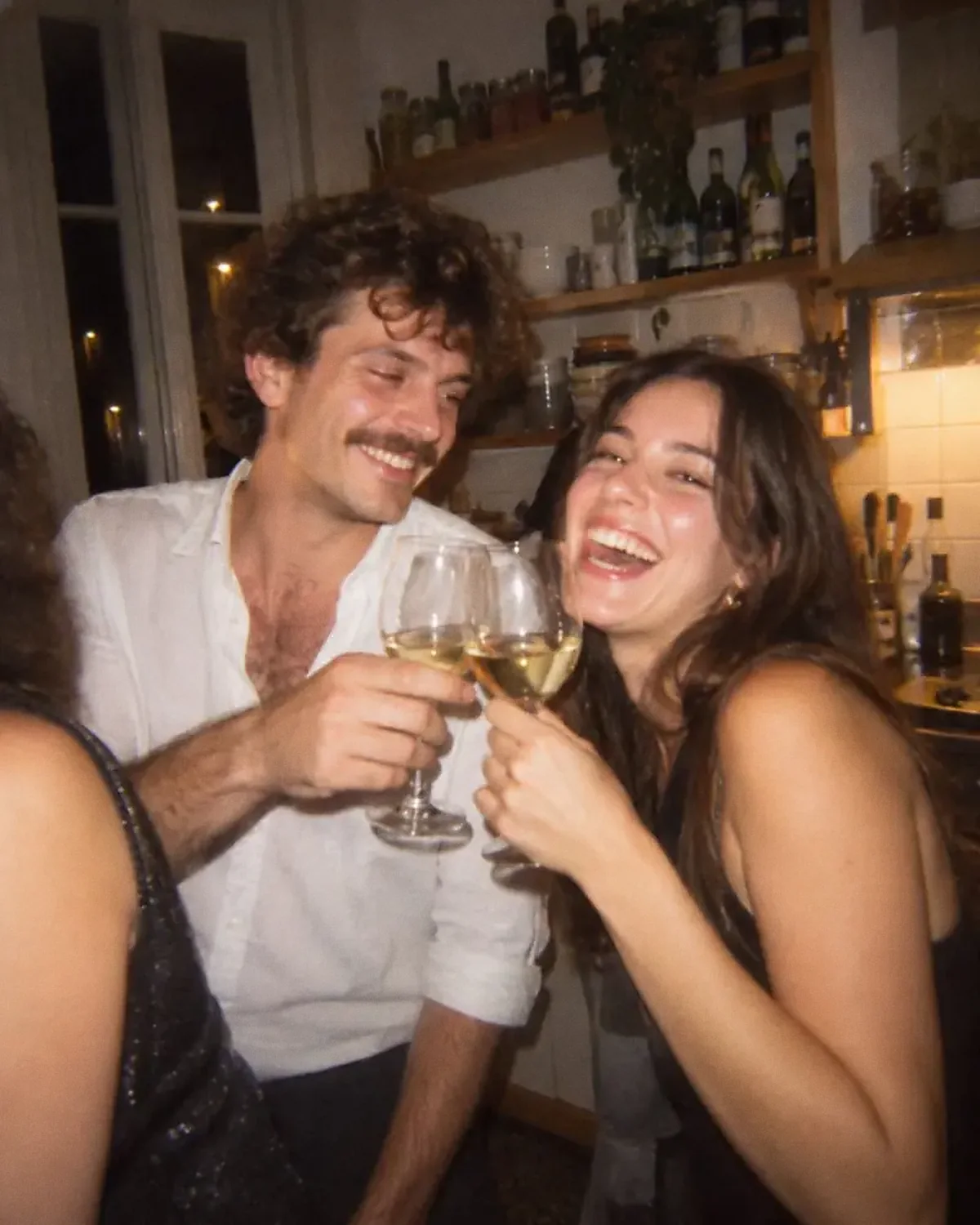 La photo d’origine : deux amis trinquent en riant dans une cuisine, le soir.